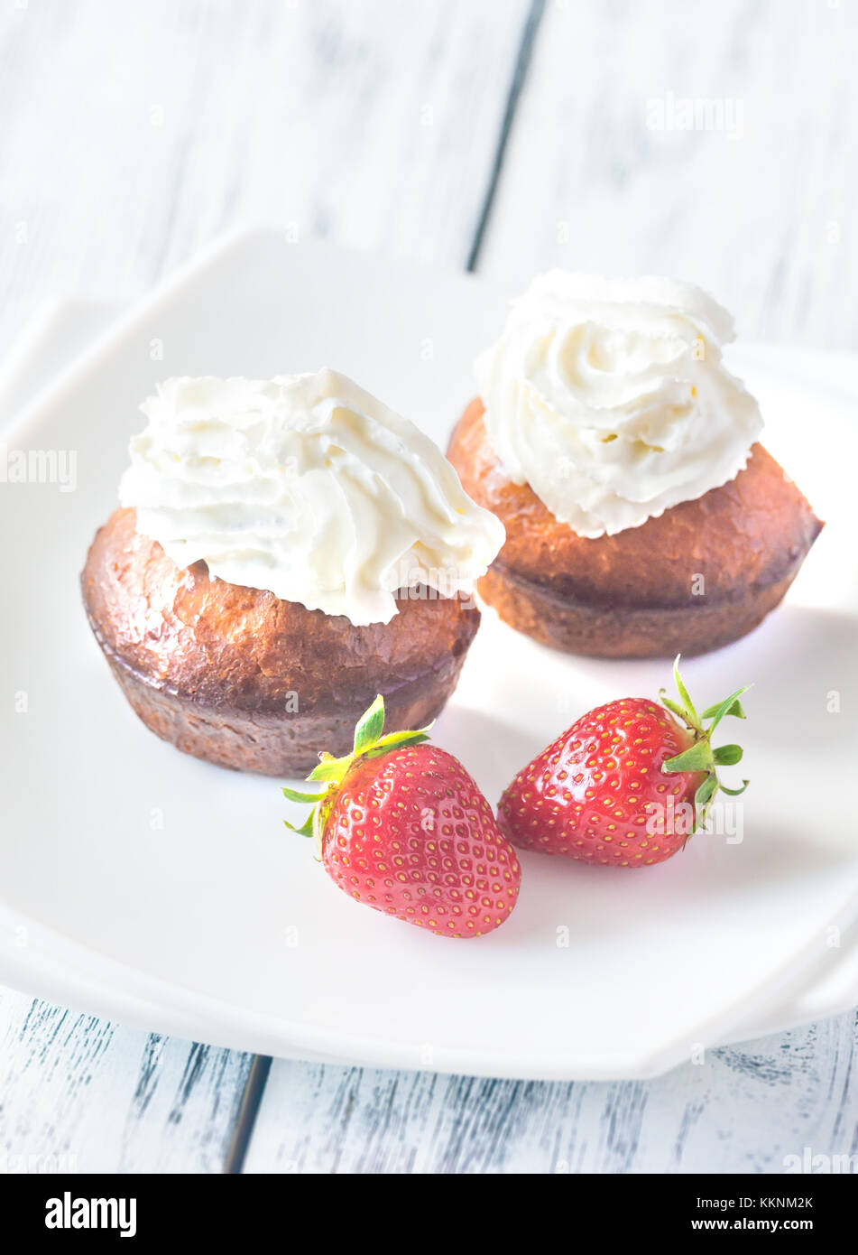 Rum baba decorated with whipped cream on the plate Stock Photo Alamy