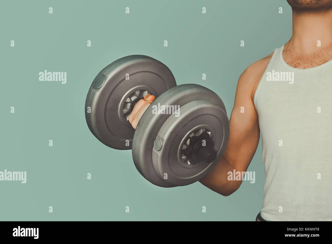 Attractive guy lifting weights. Not a professional athlete shakes muscle large dumbbells. Slim adolescent body. Home exercises for weight gain. averag Stock Photo