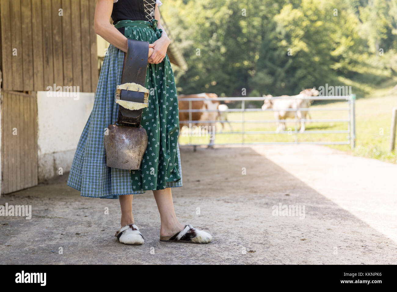 Farmer with dirndl carrying a cowbell Stock Photo