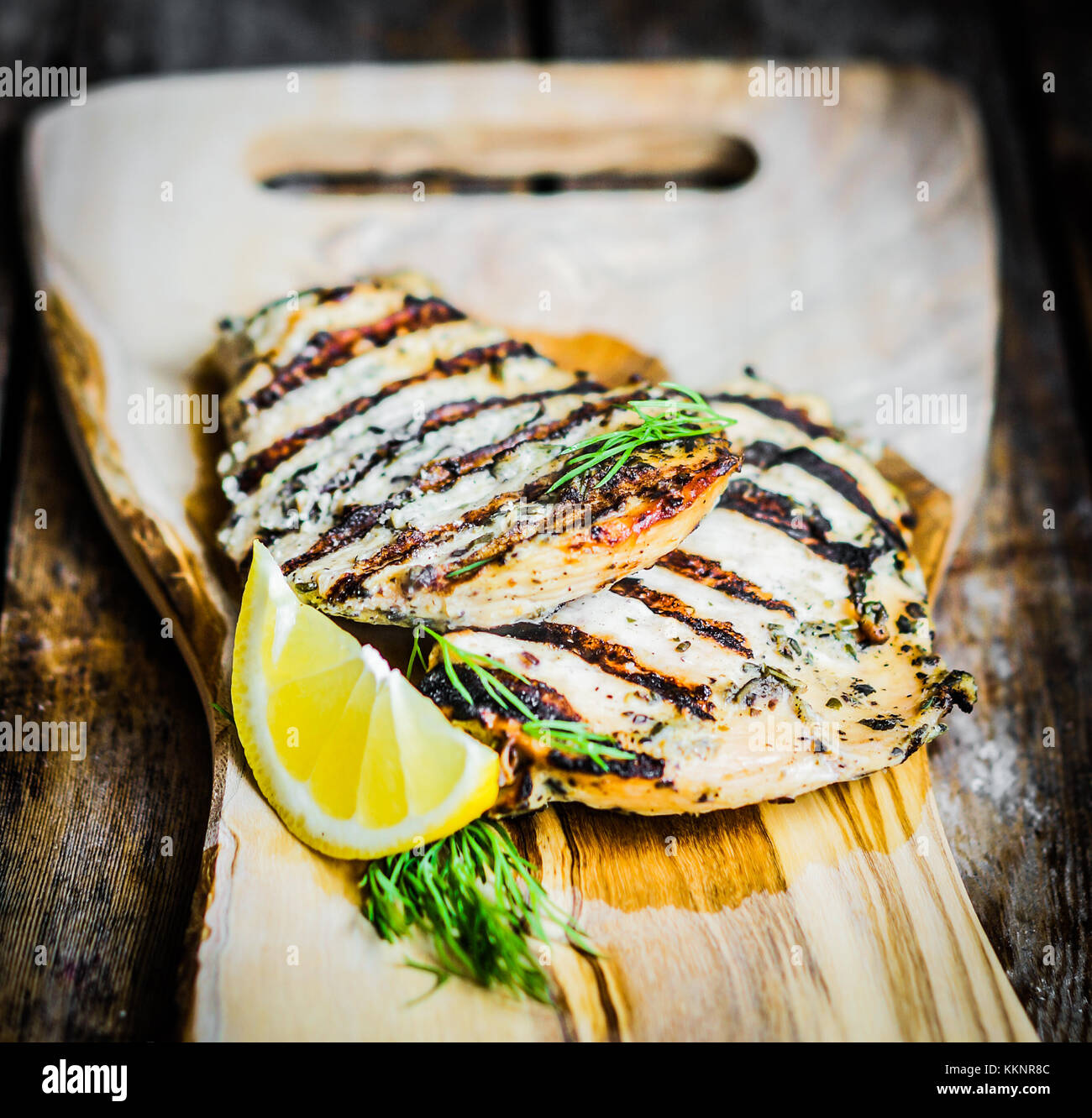 Grilled Chicken With Herbs And Lemon On Wooden Background Stock Photo