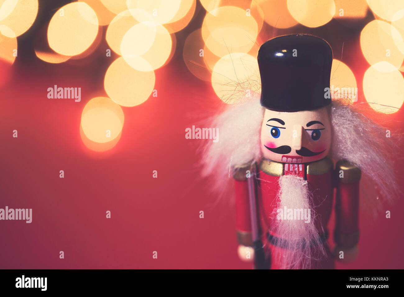 Festive nutcracker soldier with bokeh blurred fairy light Stock Photo