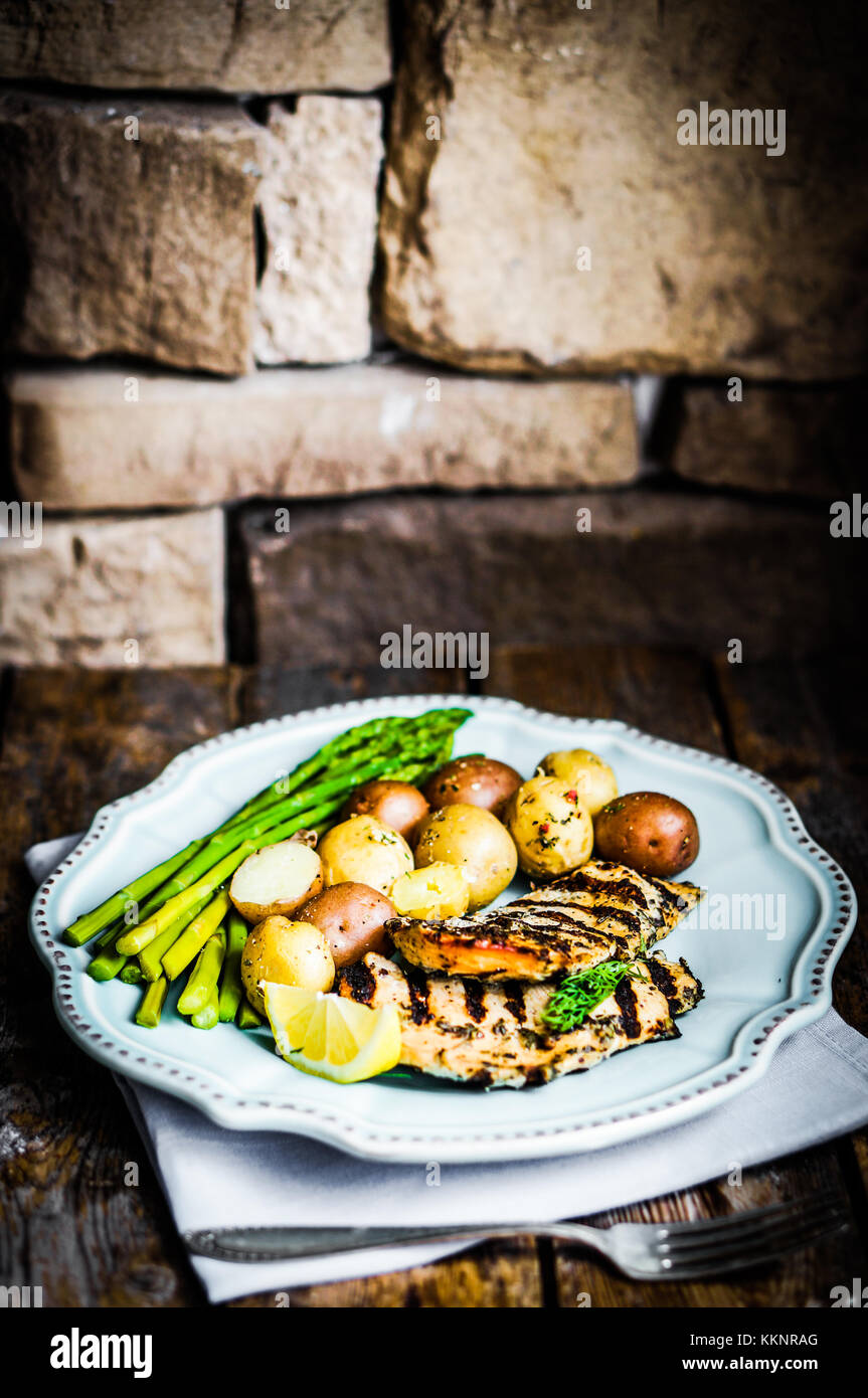 Grilled Chicken With Potatoes And Herbs On Wooden Background Stock Photo