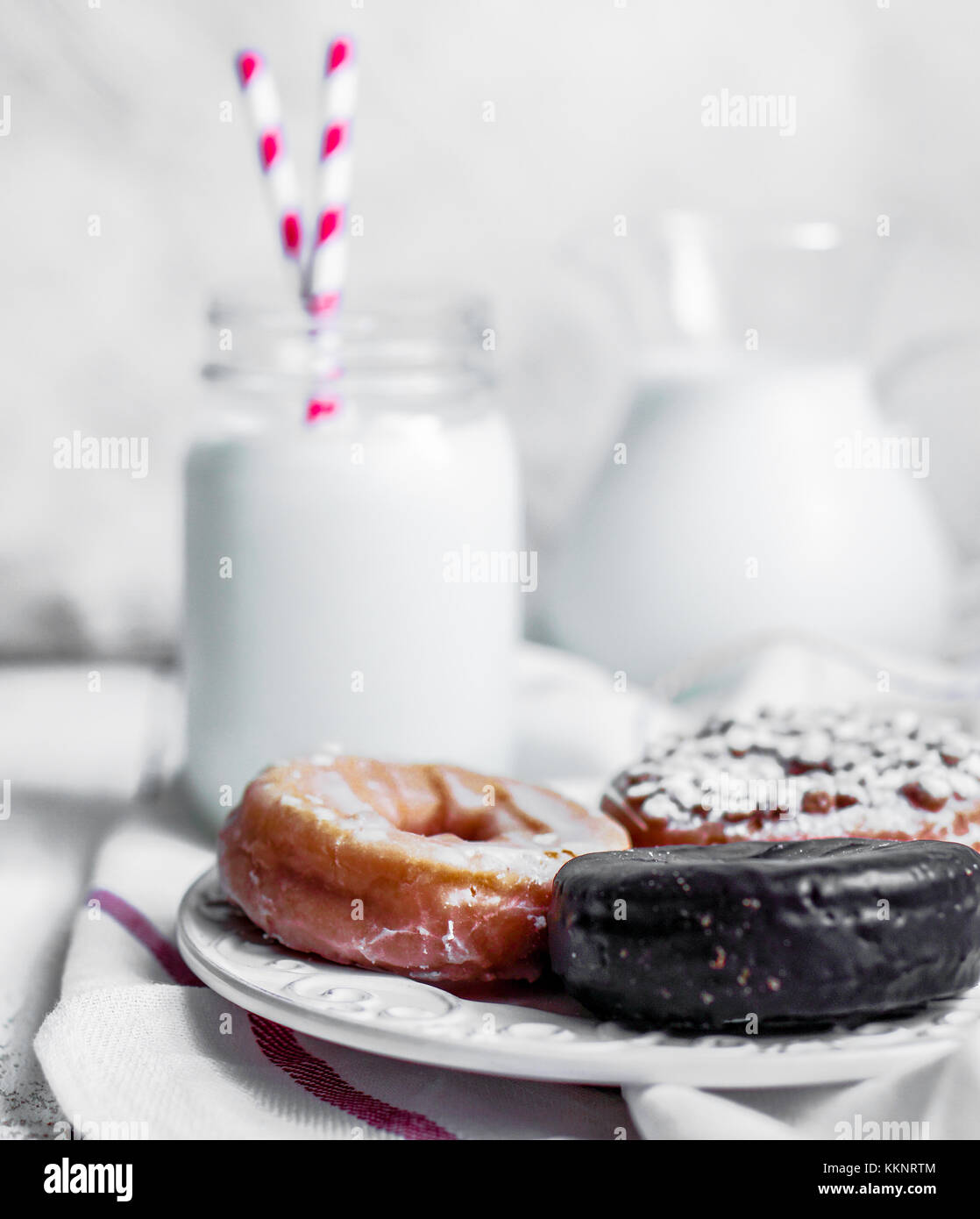 Milk And Assorted Donuts On Rustic Wooden Background Stock Photo