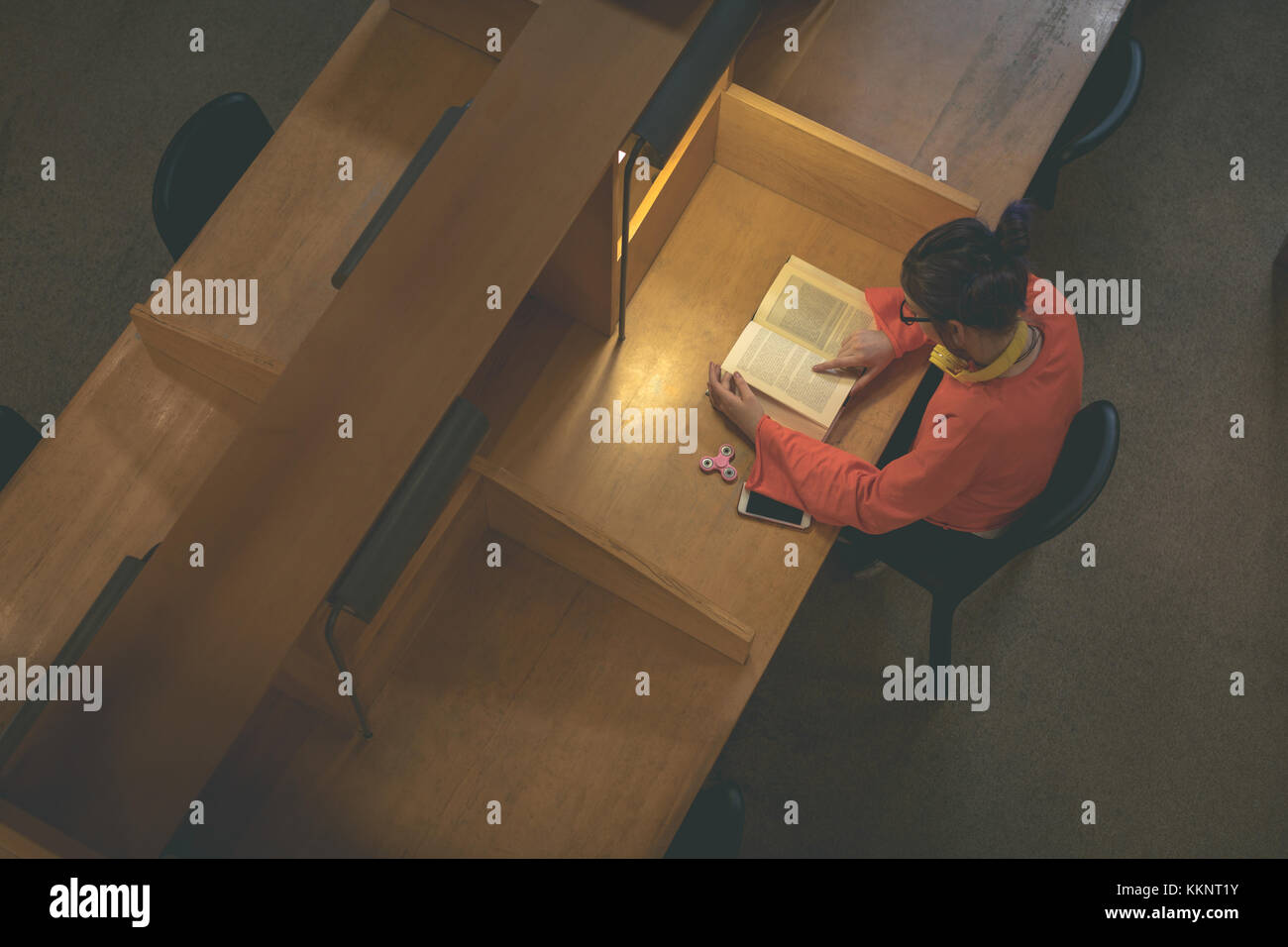 Girl reading book in library Stock Photo - Alamy