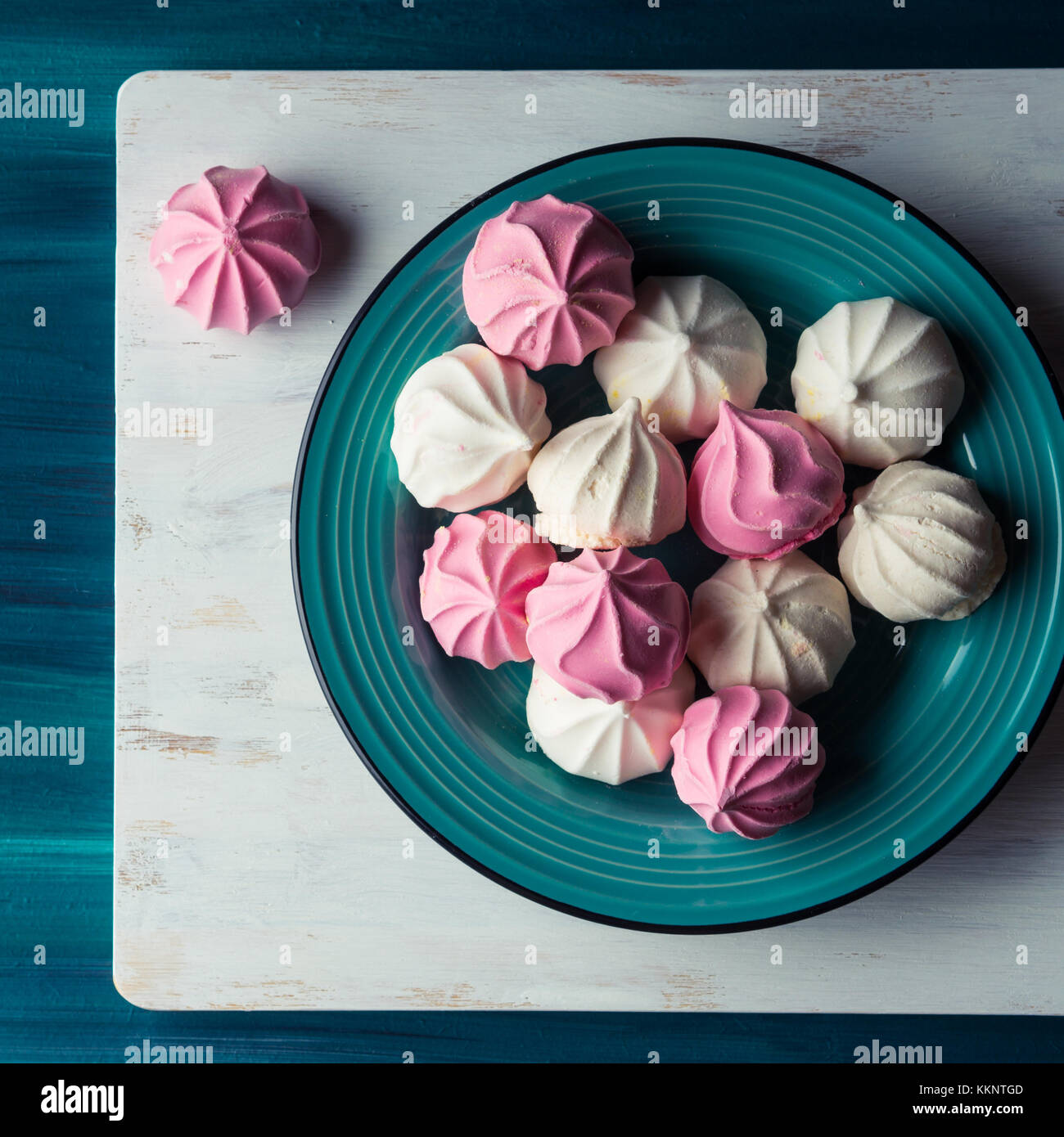 Pastel color pink and white meringue on green background Stock Photo