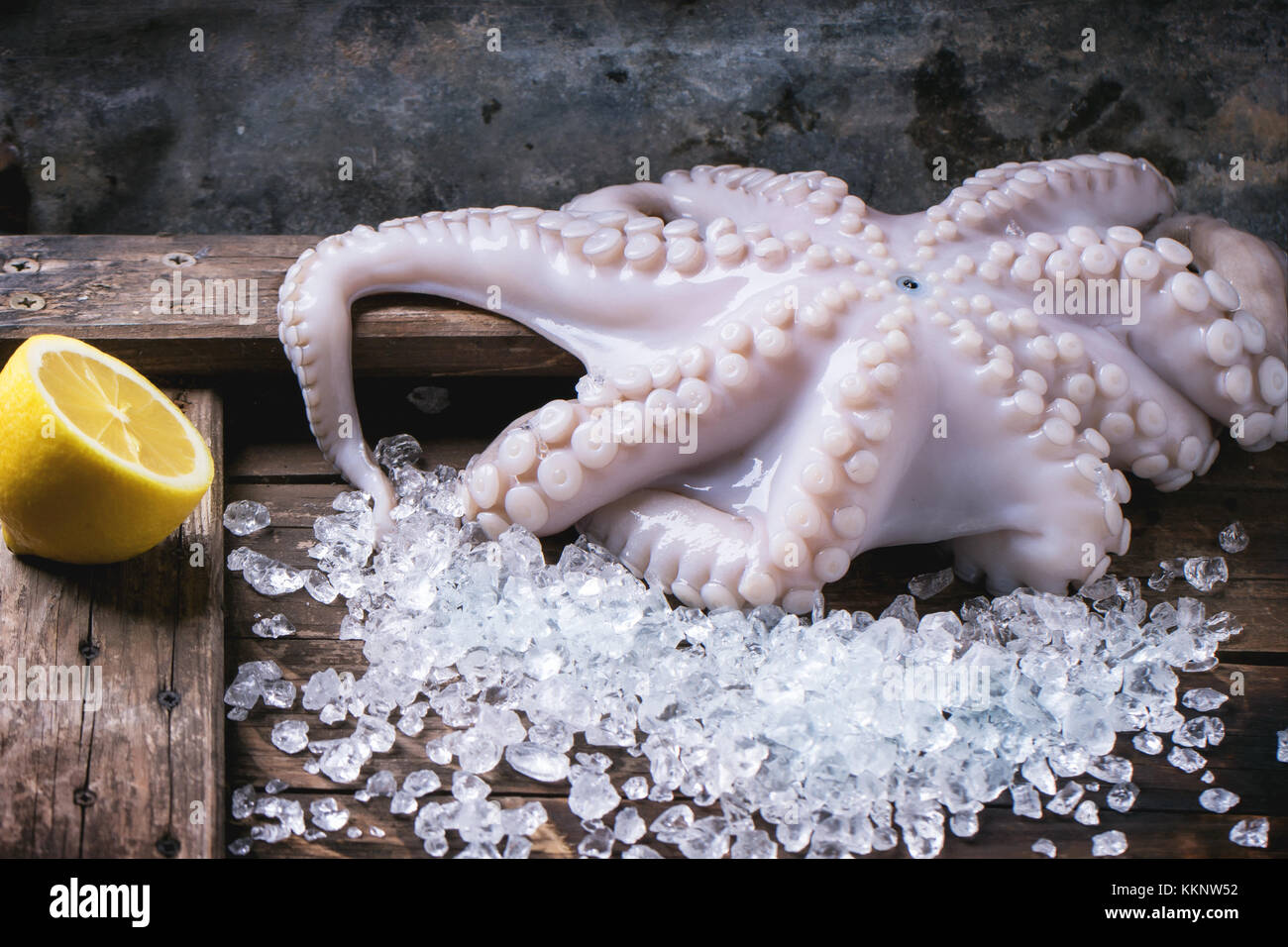 Raw octopus on ice over wooden background Stock Photo Alamy