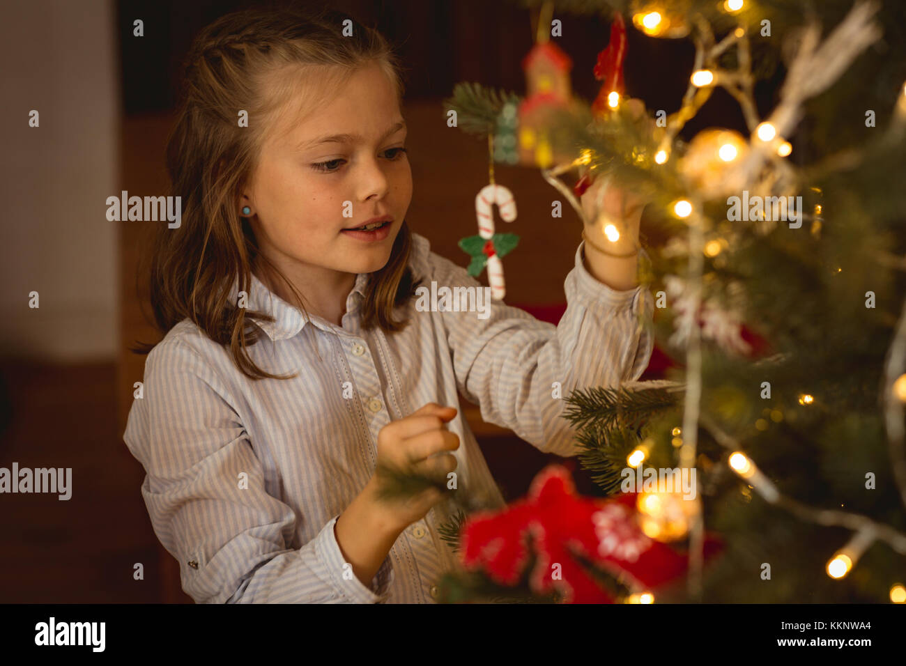 Girl decorating a chritsmas tree at home Stock Photo - Alamy