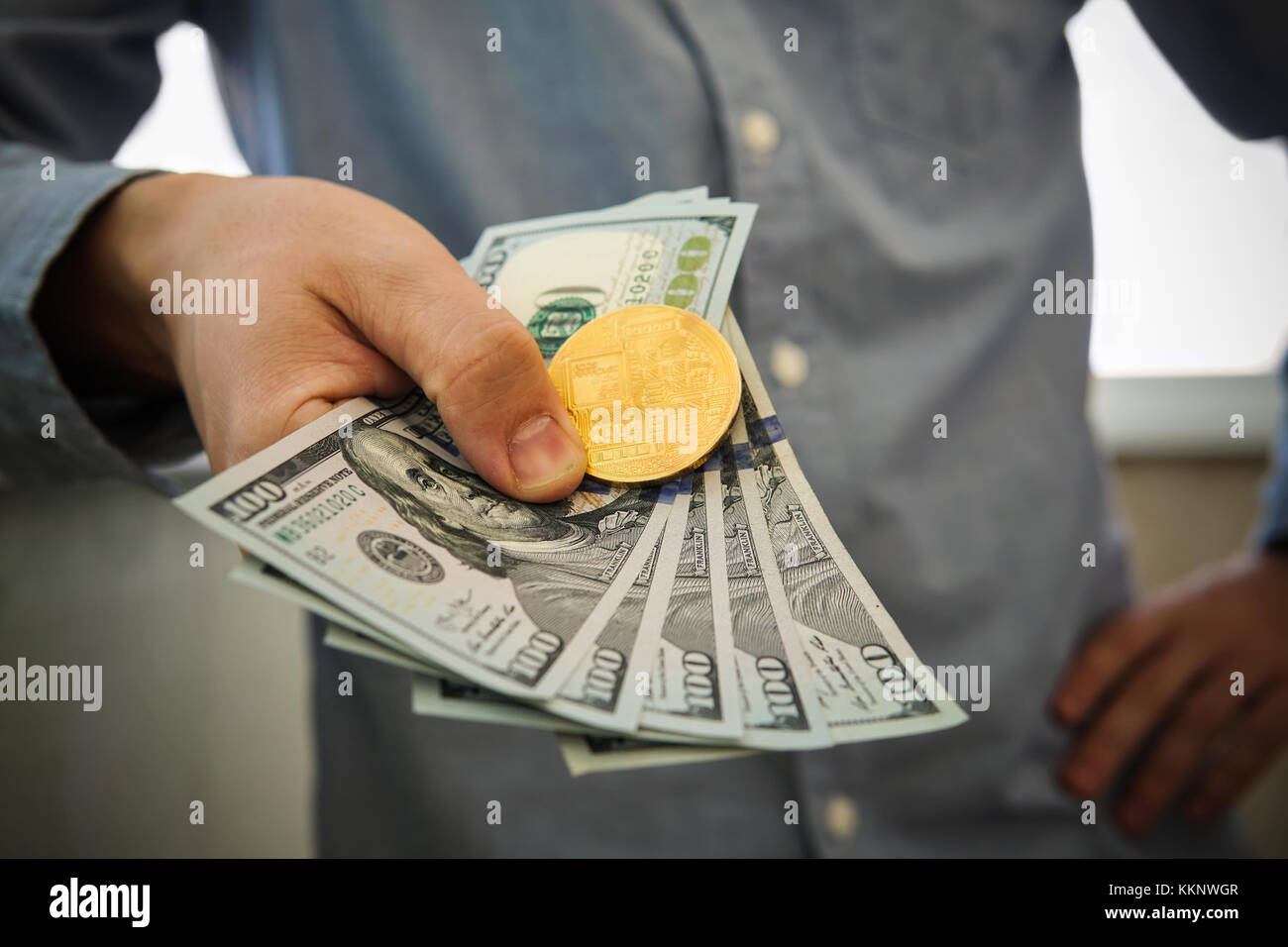 Young businessman holding dollars and coin of bitcoin in hand. Profit from  trading bitcoins Stock Photo - Alamy