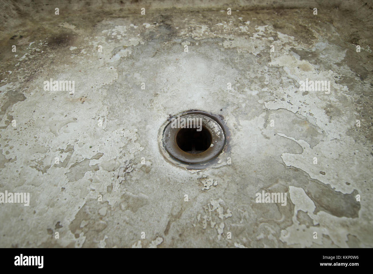 Metal drain hole in the ceramic grungre floor of a shower Stock Photo