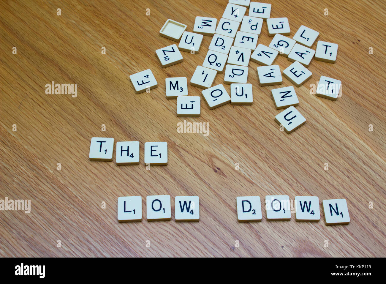 1 December 2017 Ivory board game letters saying The Low Down on an oak grain background Stock Photo