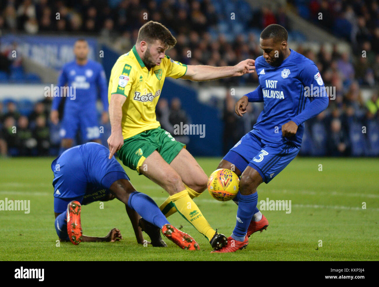 Norwich City's Grant Hanley (centre) and Cardiff City's Joe Bennett battle for the ball during the Sky Bet Championship match at the Cardiff City Stadium, Cardiff. PRESS ASSOCIATION Photo Picture date: Friday December 1, 2017. See PA story SOCCER Cardiff. Photo credit should read: Simon Galloway/PA Wire. RESTICTIONS: EDITORIAL USE ONLY No use with unauthorised audio, video, data, fixture lists, club/league logos or 'live' services. Online in-match use limited to 75 images, no video emulation. No use in betting, games or single club/league/player publications. Stock Photo