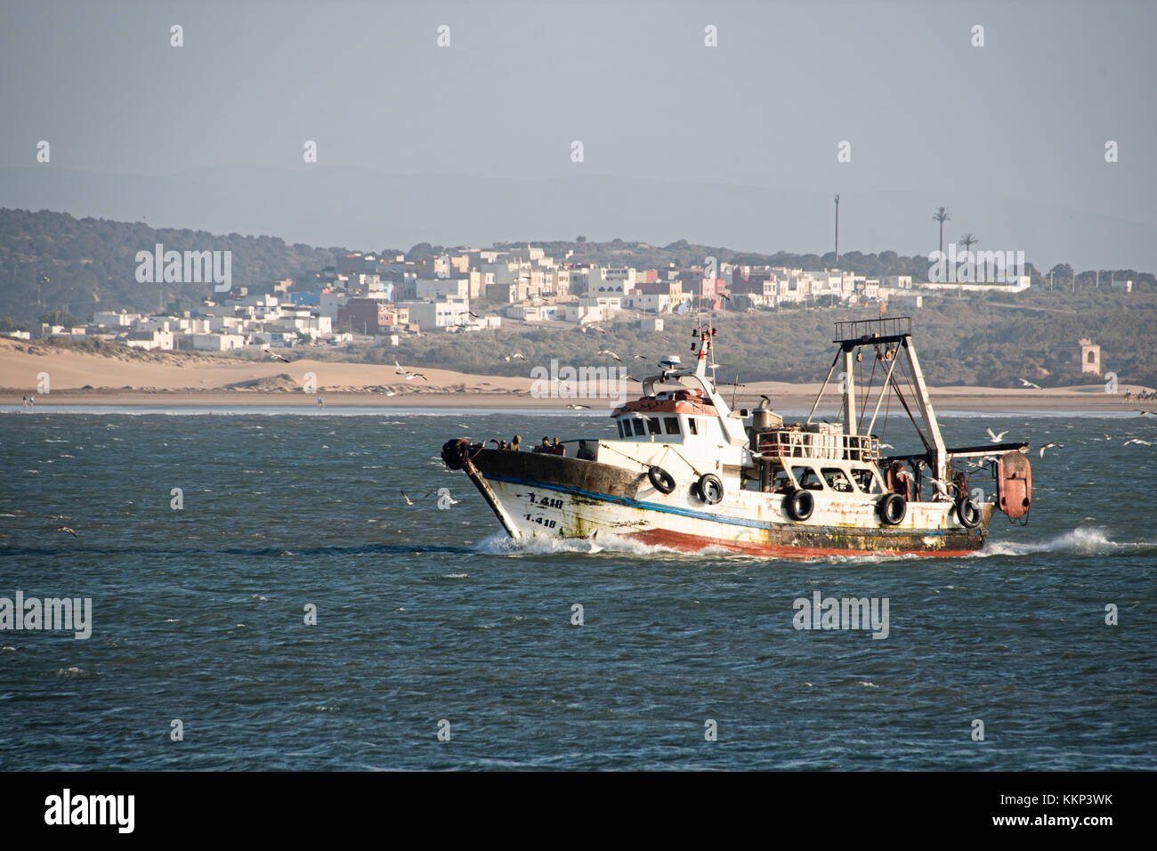Fishing boat returning to harbour Stock Photo - Alamy