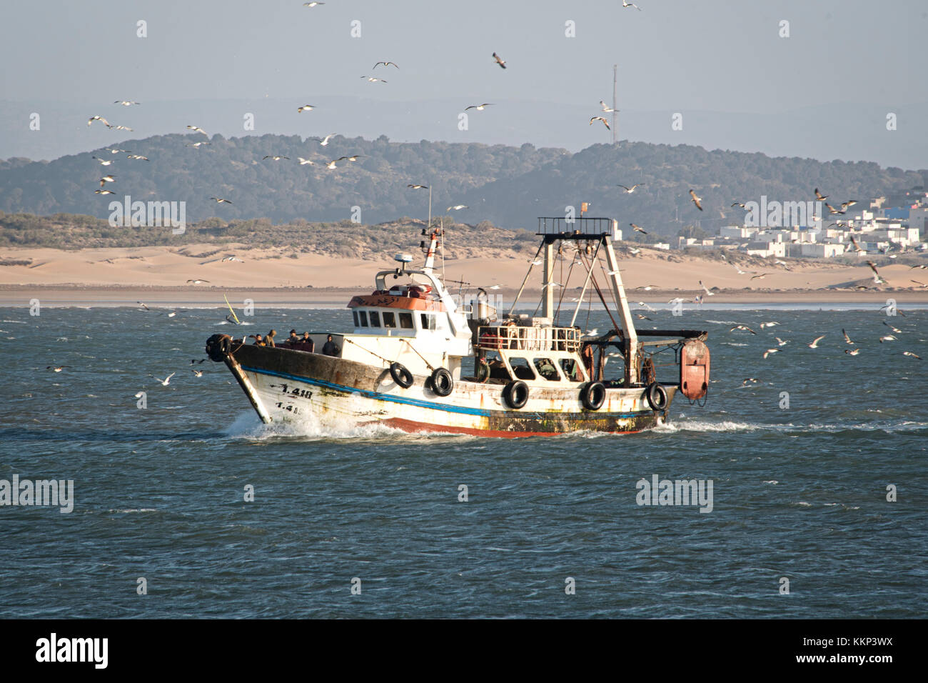Fishing boat returning to harbour Stock Photo - Alamy