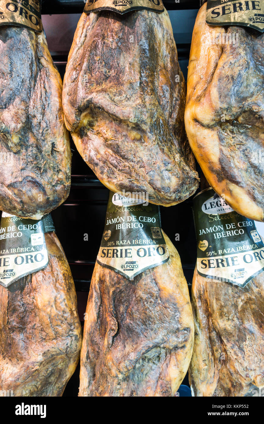 Whole legs of cured Iberian ham hanging in the butchery department of a