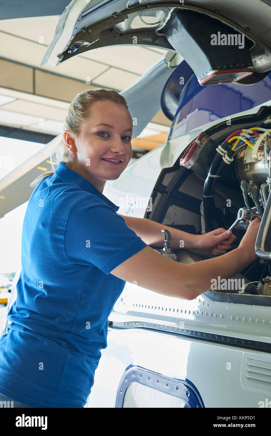 Portrait Of Female Aero Engineer Working On Helicopter In Hangar Stock Photo