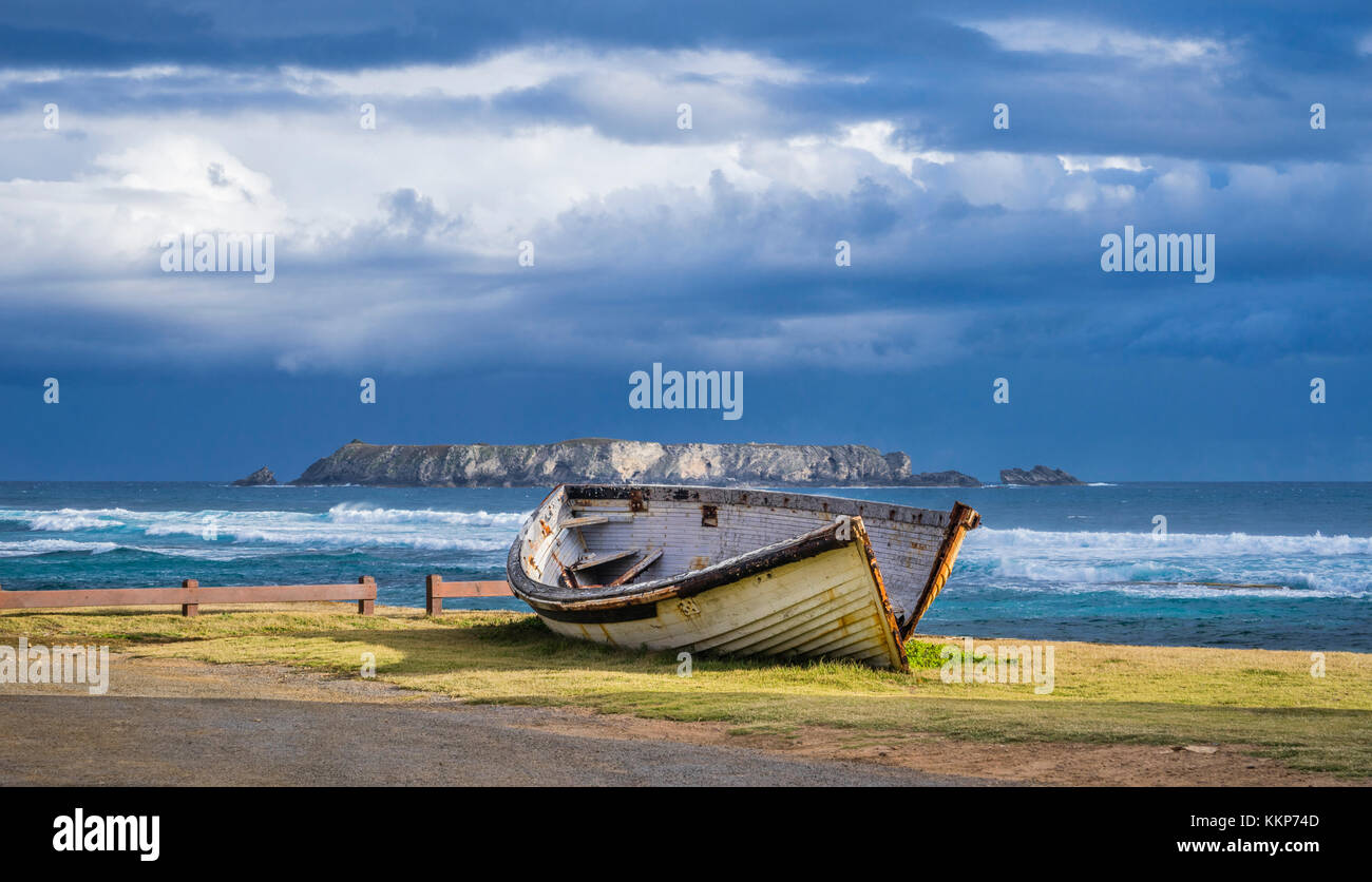 Norfolk Island, Australian external territory, boat wreck at Kingston pier against the backdrop of Nepean Island Stock Photo