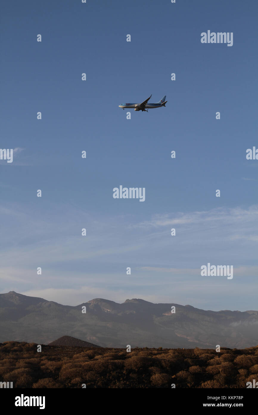 Airplane flying over mountain in Tenerife. Blue sky and clear day Photo
