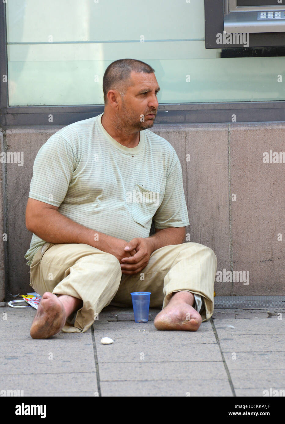 Strasbourg, France - July 7, 2012: a disabled person asks for money near the ATM. Editorial only. Stock Photo