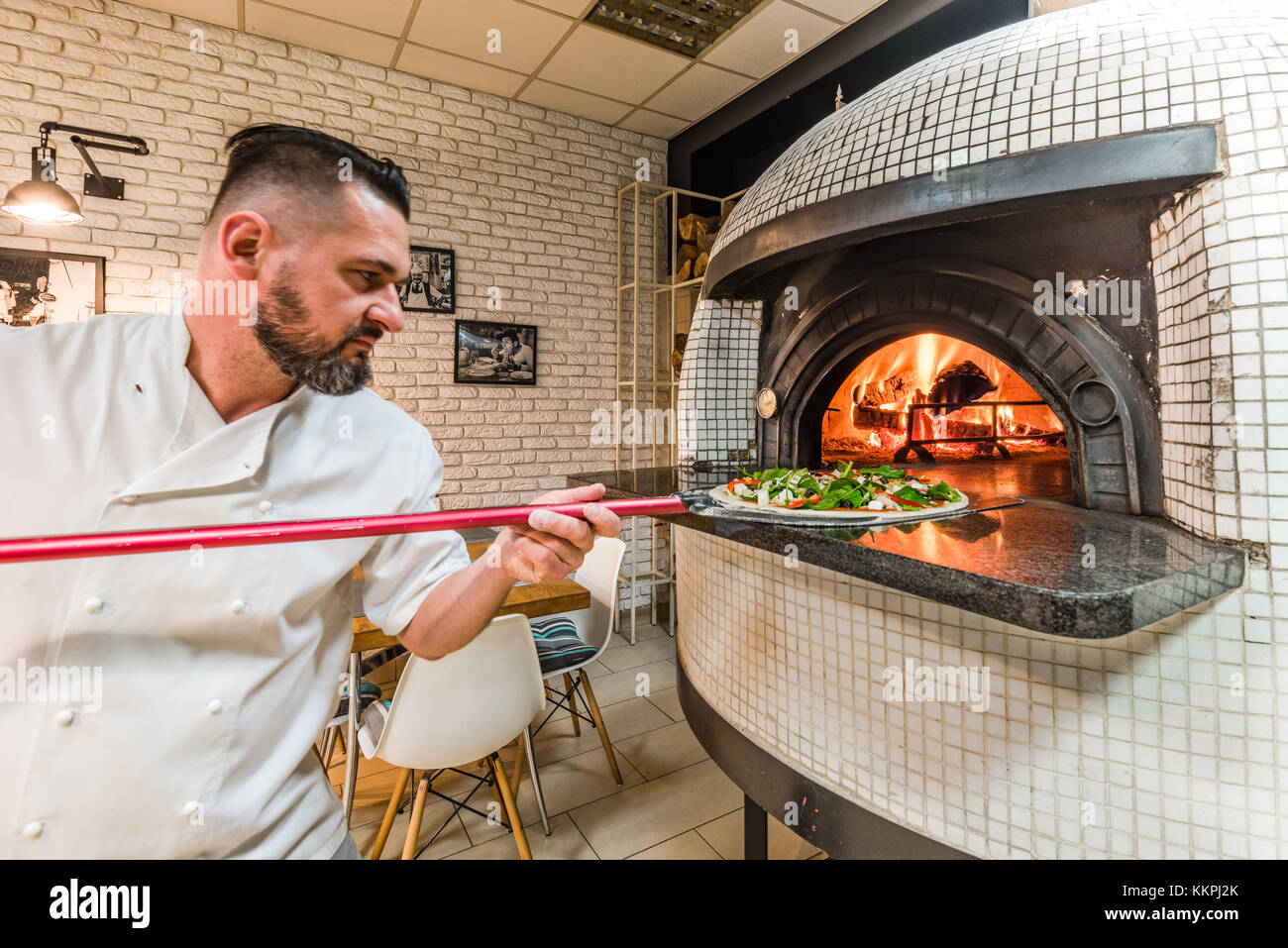 Bearded pizzaiolo man baking pizza in woodfired oven in local pizzeria  Stock Photo - Alamy