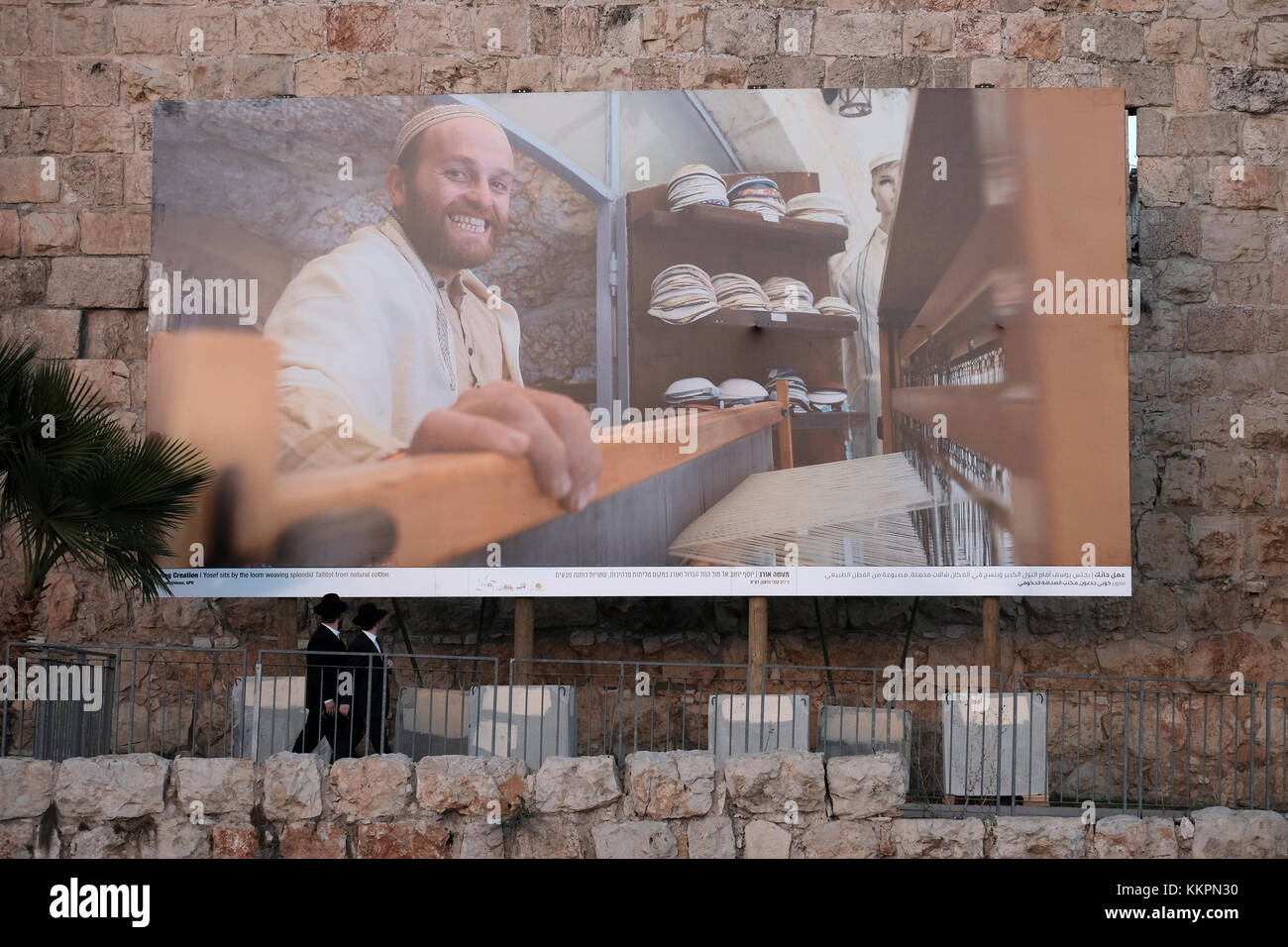 Talutot Orthodox Jews passing by a huge photograph depicting a Jew weaving ...