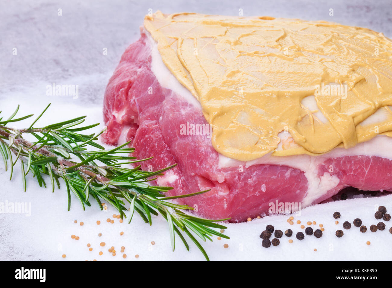 Roast with crackling, coated with mustard, preparation Stock Photo