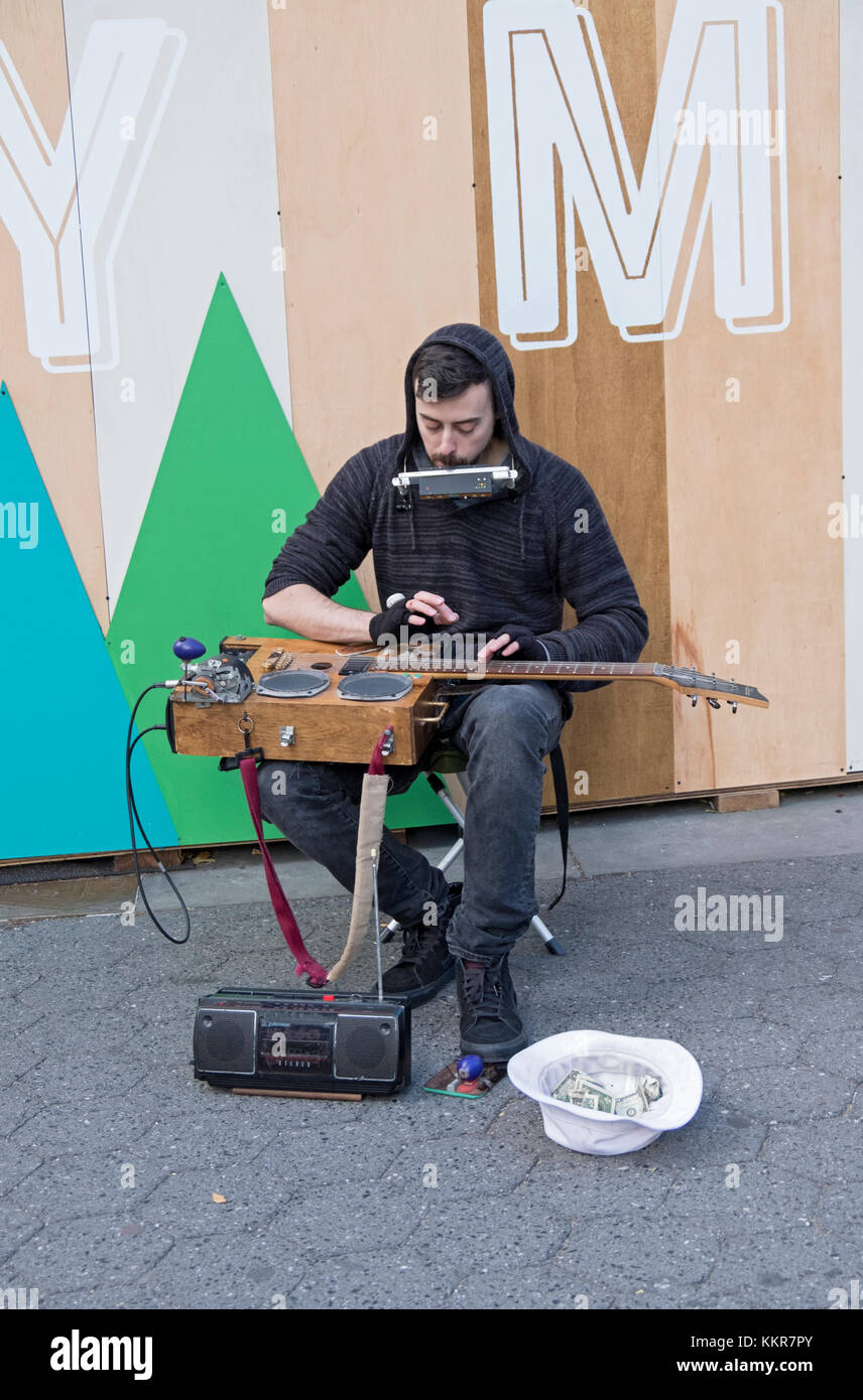 A one man band musician playing a homemade instrument for donations outside the Union Square Holiday Market in New York Stock Photo
