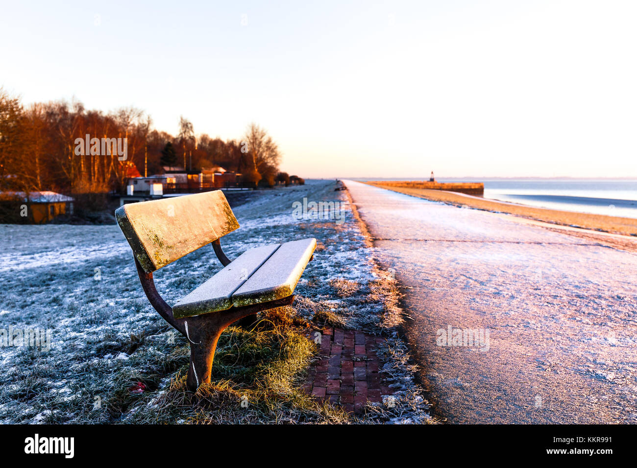 A frozen bench on the dike near the Schleuseninsel at Wilhelmshaven. From here you can look to the Jade-Busen. Stock Photo