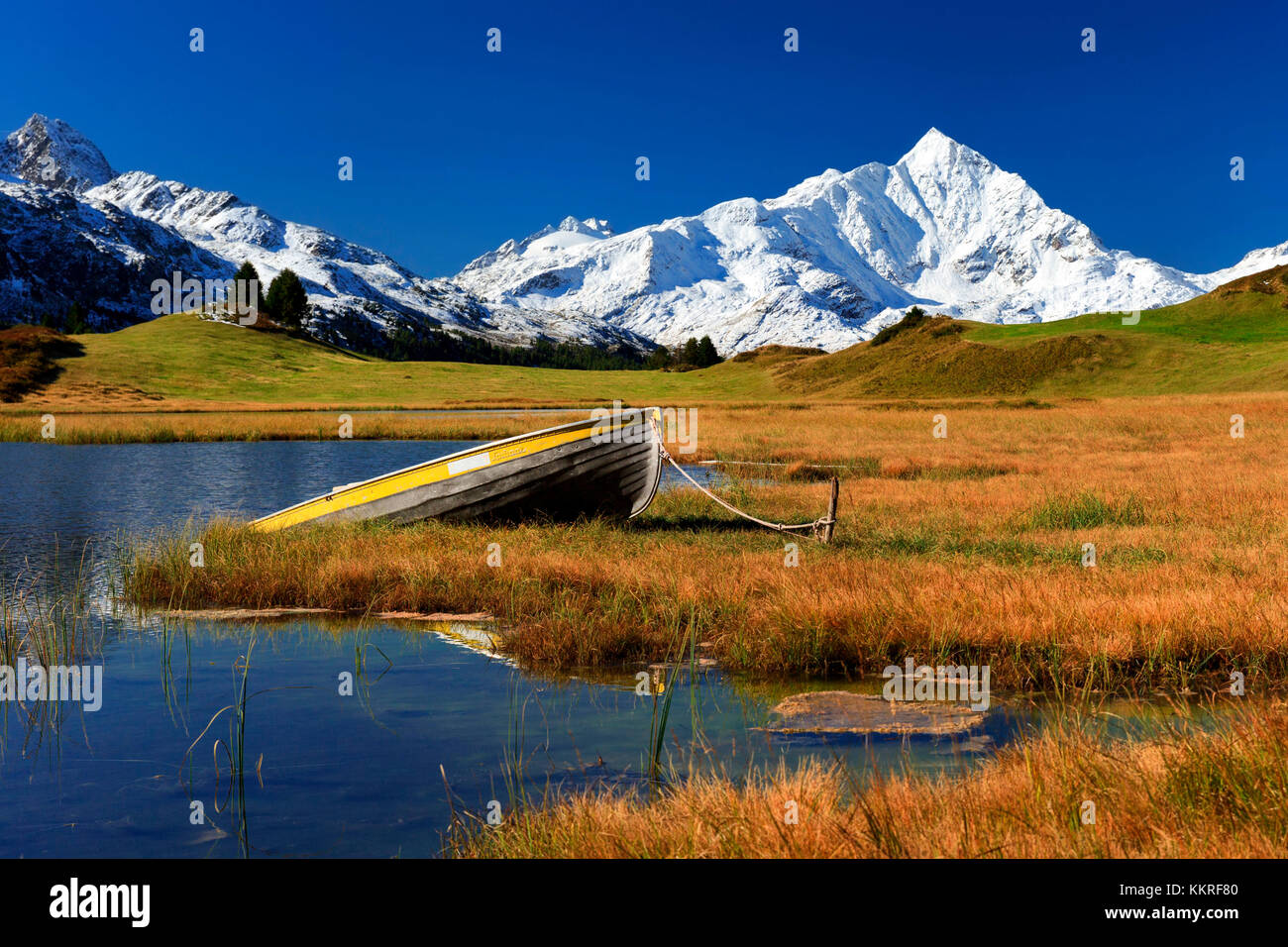 A boat at the shore of the small lake Lai da Vons, with Piz Tambo mirrroing into the lake, Sufers, Grisons, Switzlerand Stock Photo