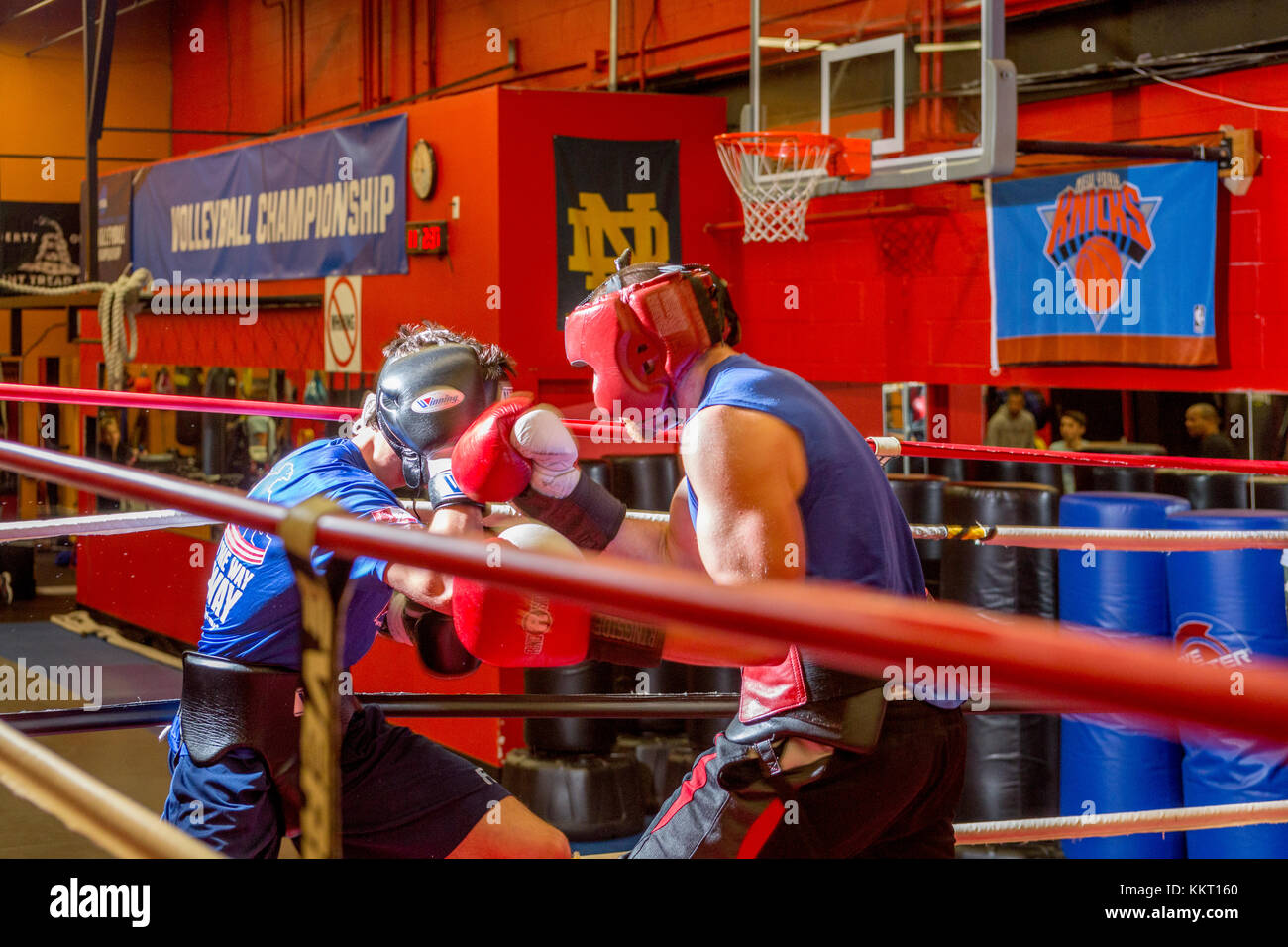 Amateur boxers wearing protective headgear sparring in a gym Stock