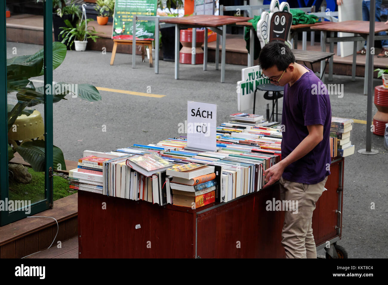 HO CHI MINH, VIET NAm, Reader reading book at bookstore, publishing company show colorful books outdoor of shop, reading lost in modern society Stock Photo