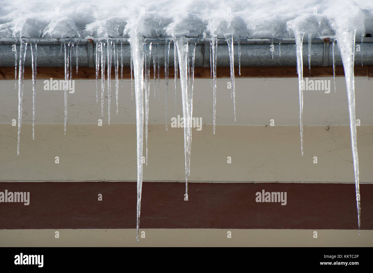 Dangerous icicles in a house roof Stock Photo