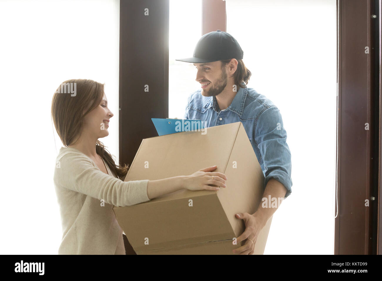 Delivery service concept, woman receiving box from courier at ho Stock Photo