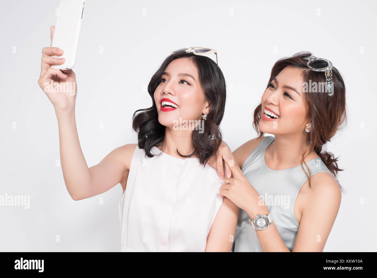 Two happy asian young women with smartphone taking selfie Stock Photo ...