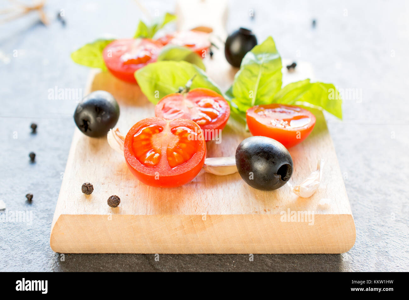 Selective focus on the front sliced cherry tomato and black olive Stock Photo