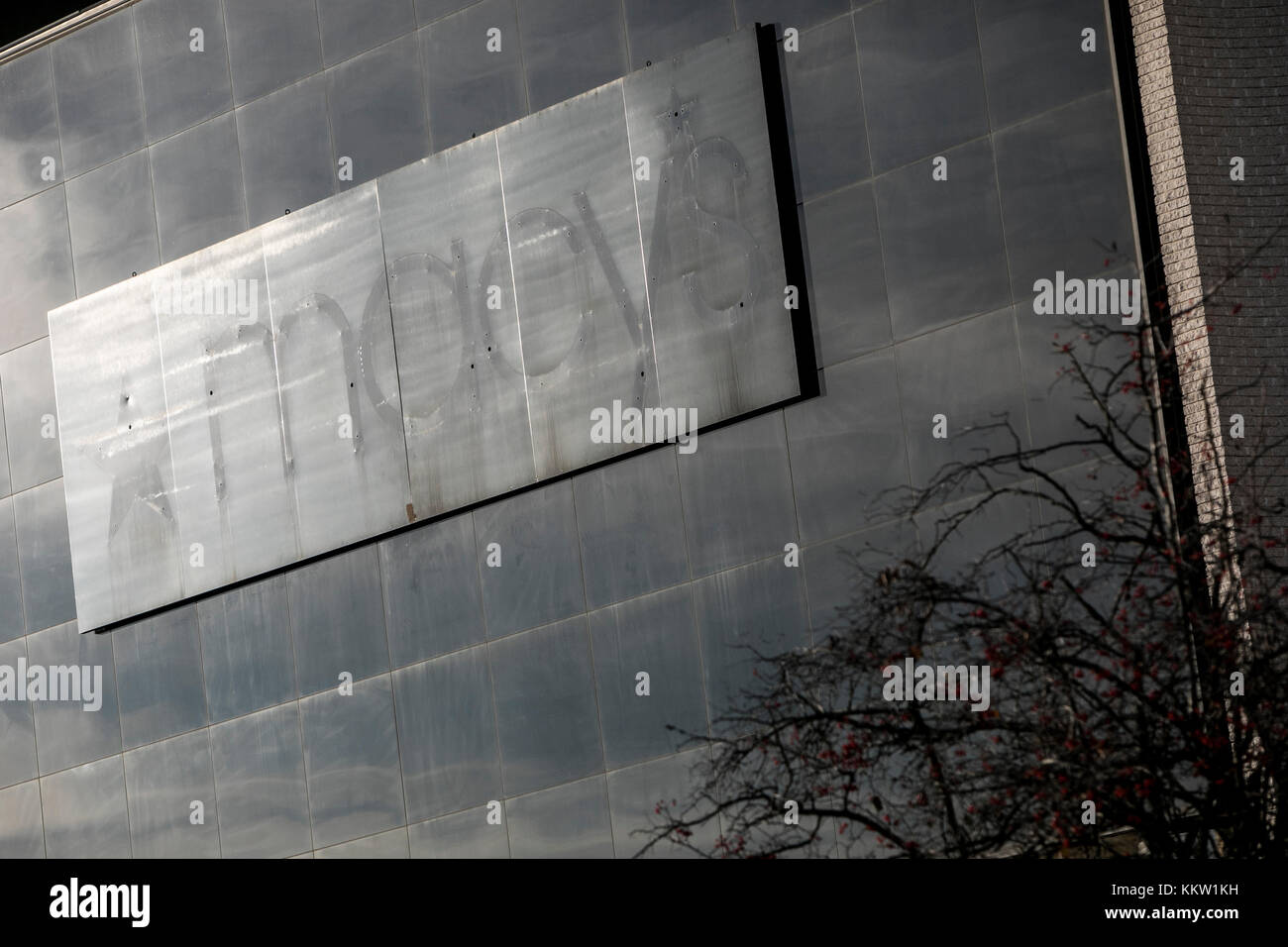 The outline of a Macy's logo sign outside of a now closed retail store