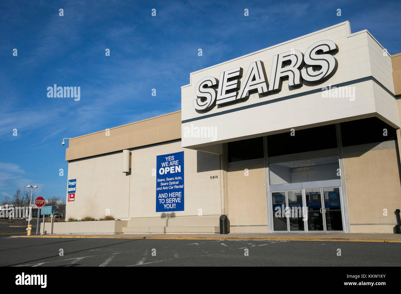 A logo sign outside of a Sears retail store in Alexandria, Virginia on