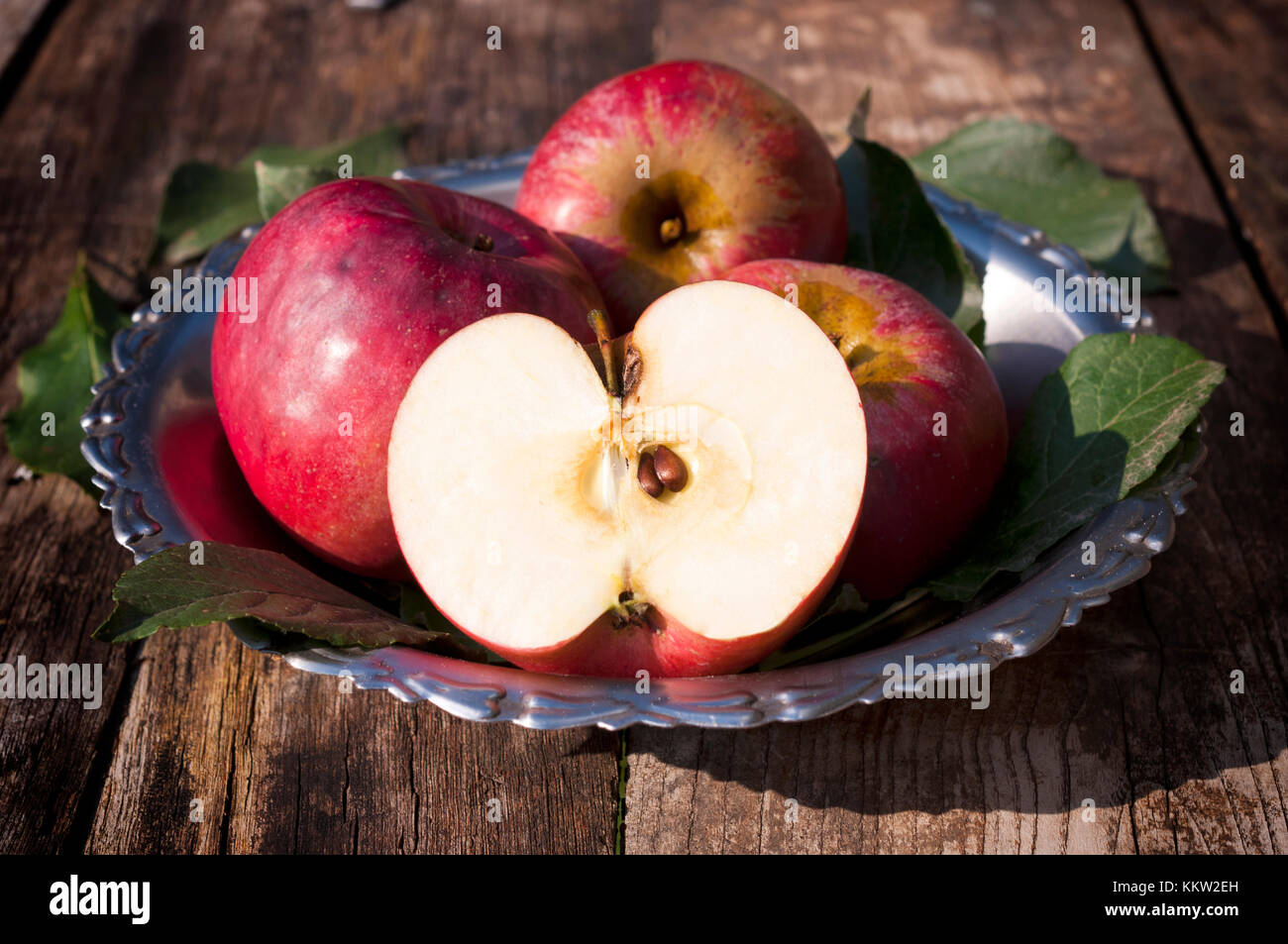 Real organic apples in metal plate.Selective focus on the front sliced apple Stock Photo