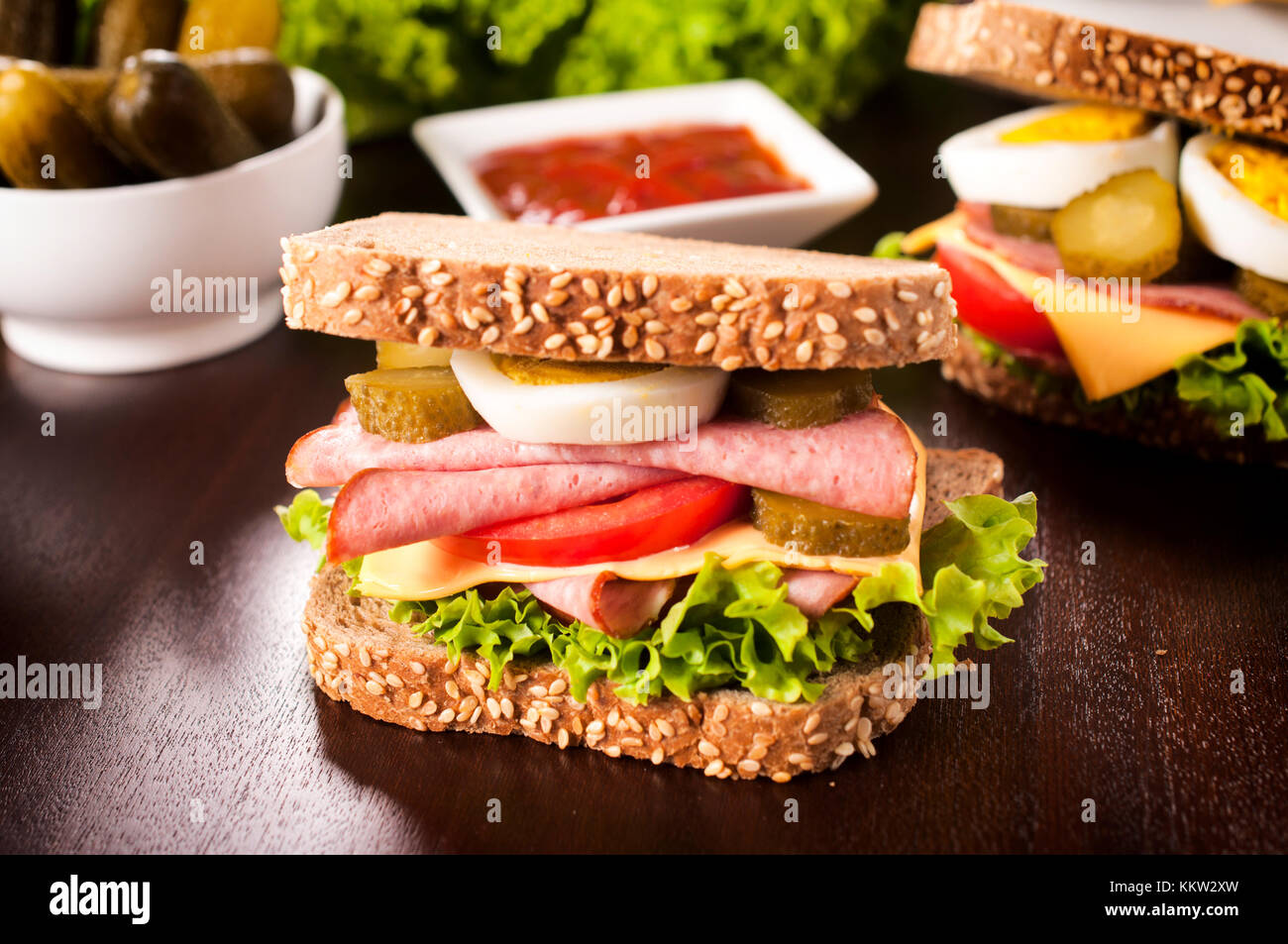 Tasty big sausage sandwich on the wooden table Stock Photo