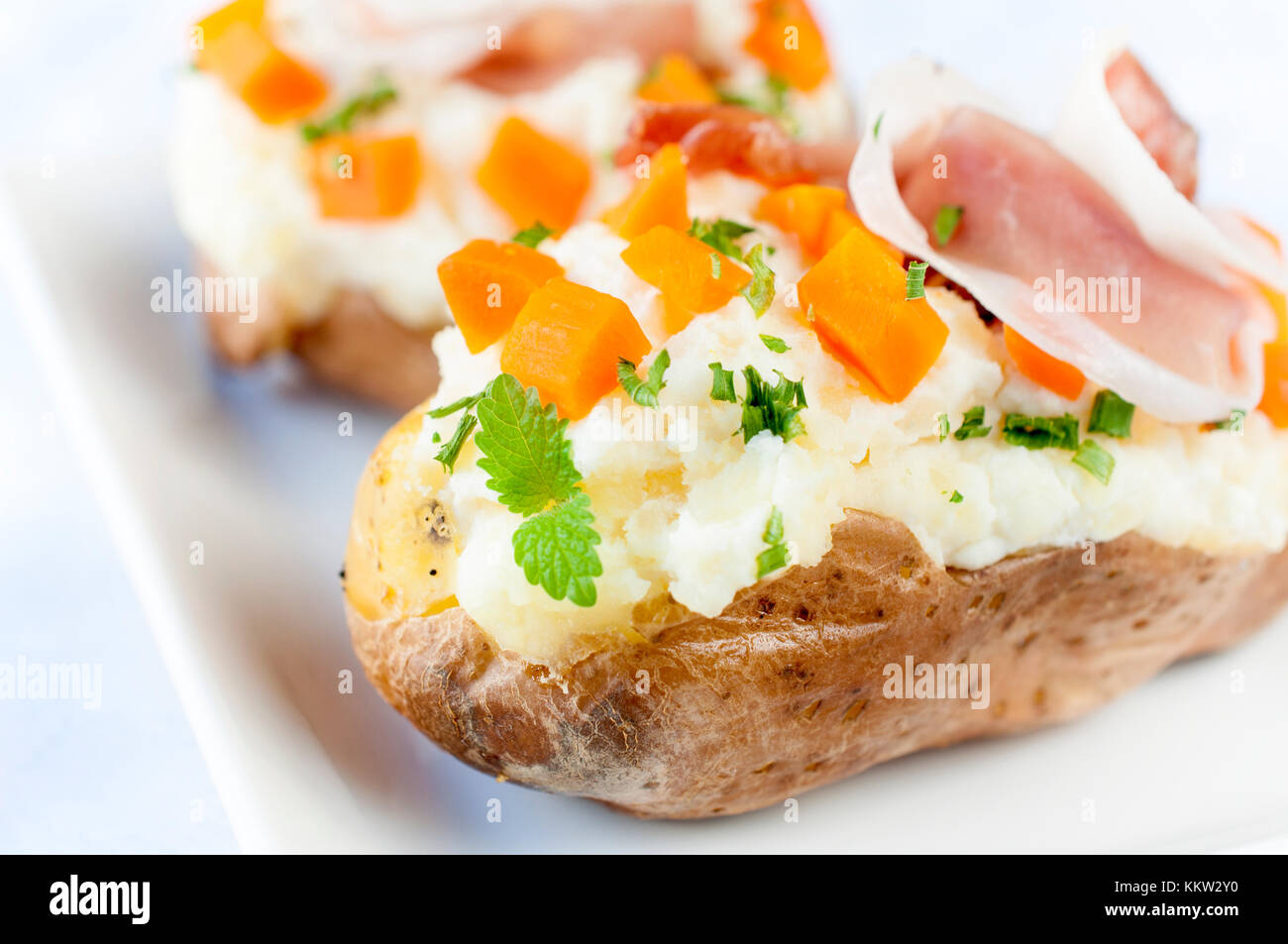 Tasty potato stuffed with cheese cream and prosciutto Stock Photo