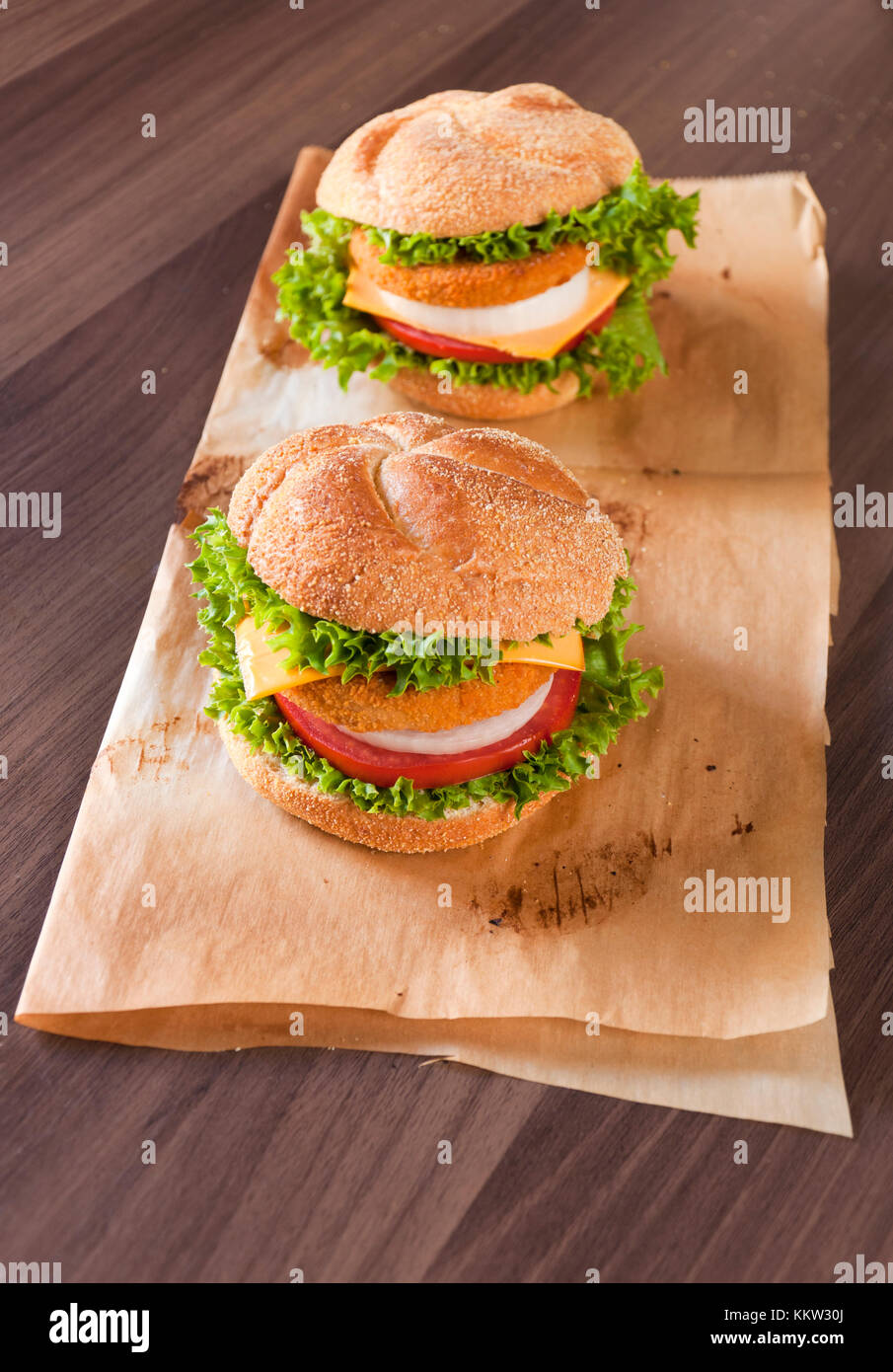 Two fish burgers on the wooden table Stock Photo