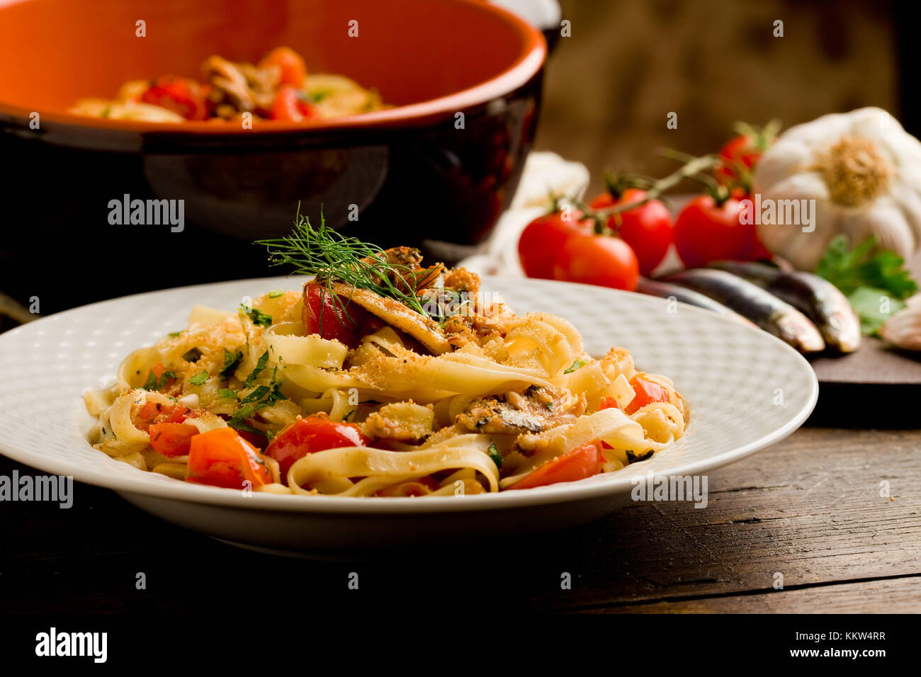 Italian regional dish made of pasta with sardines on wooden table Stock