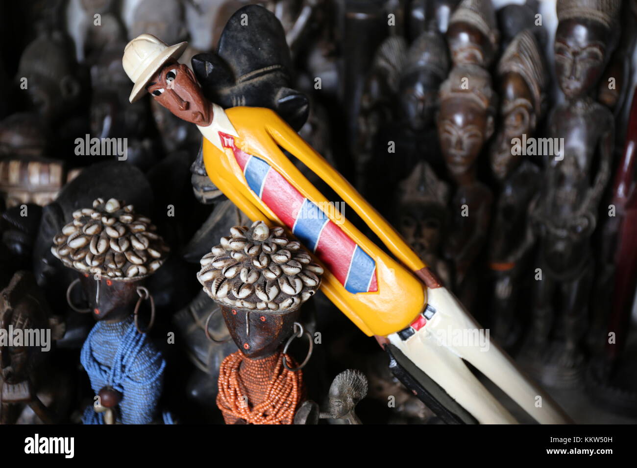 a colored statue among heads of other statues from ivory coast. Stock Photo