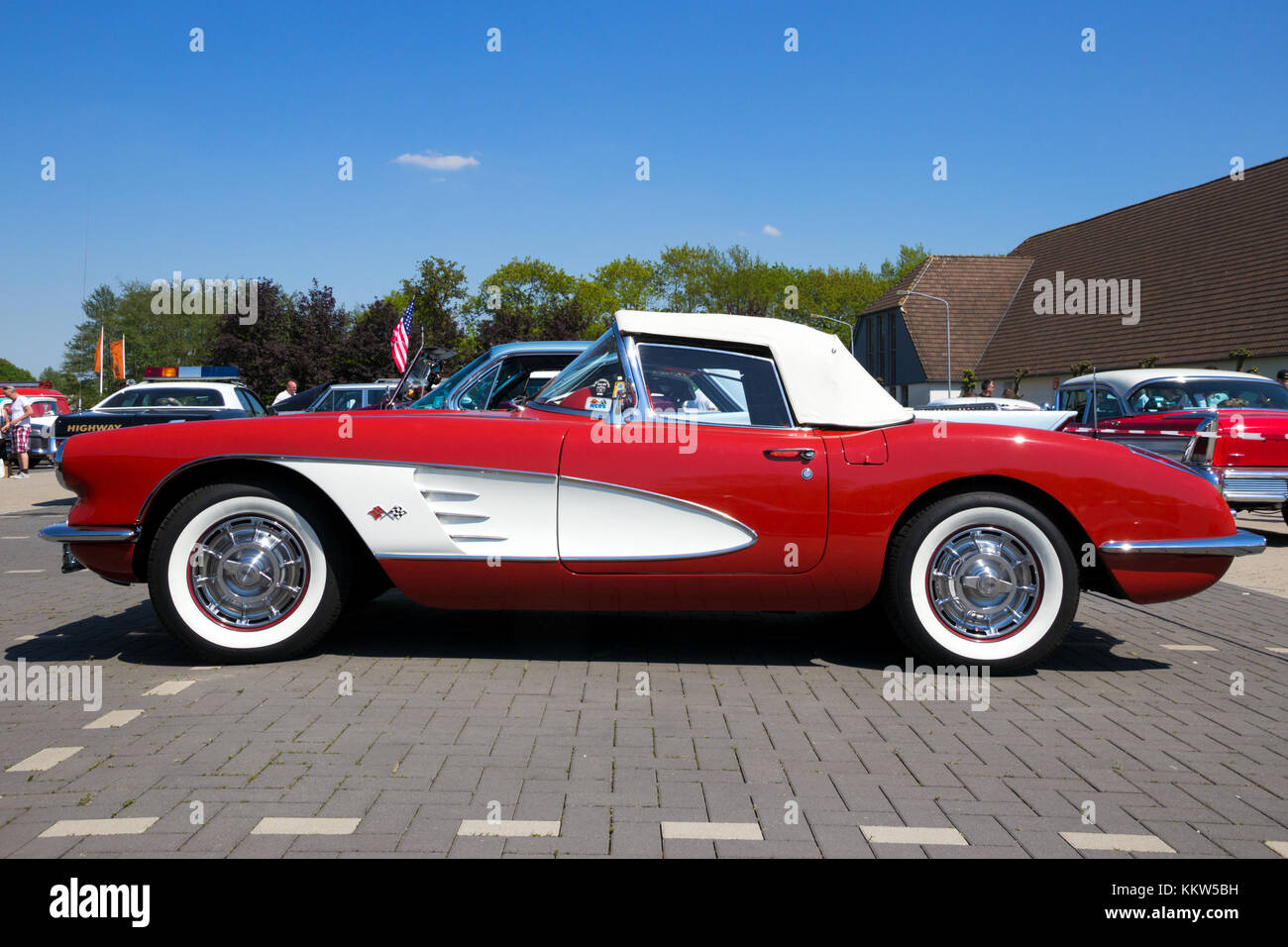 DEN BOSCH, THE NETHERLANDS - MAY 10, 2016: Side view of a parked red and white 1960 Chevrolet Corvette Roadster vintage car. Stock Photo