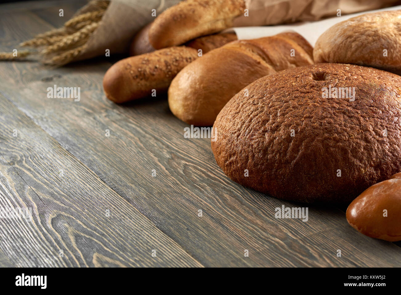 Fresh bread on wooden worktop Stock Photo