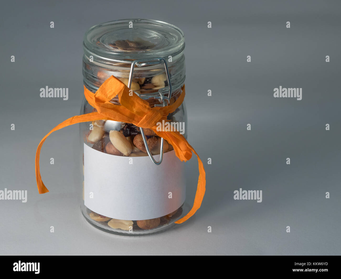 mixed nuts in a jar with a orange ribbon Stock Photo