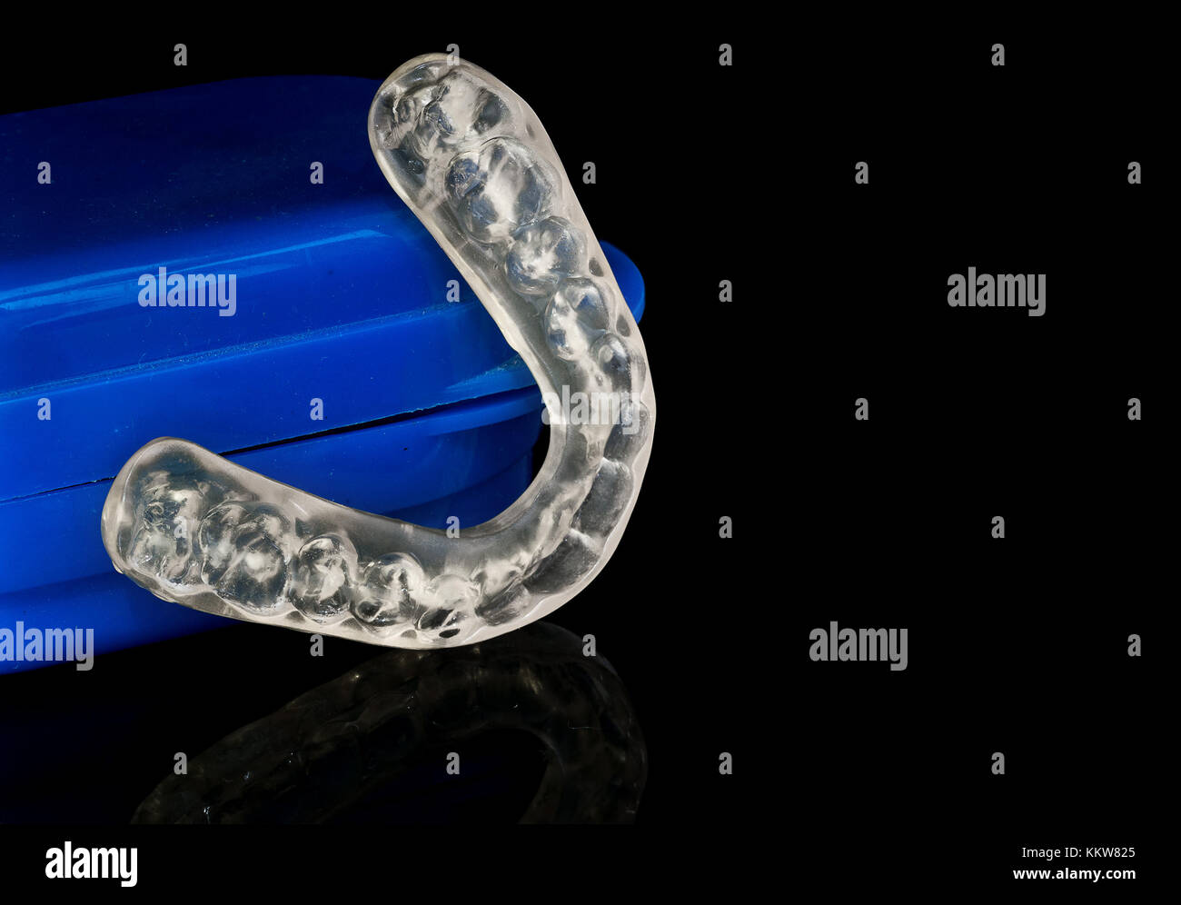 Acrylic transparent dental Mouth Guard on black background, showing reflection, used to treat and avoid bruxism (teeth grinding) Stock Photo