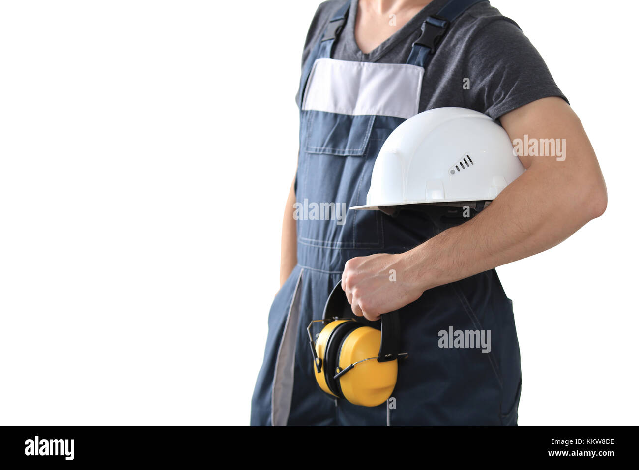 Worker holding white helmet and safety headphones isolated on white background. Protective wear theme. Stock Photo