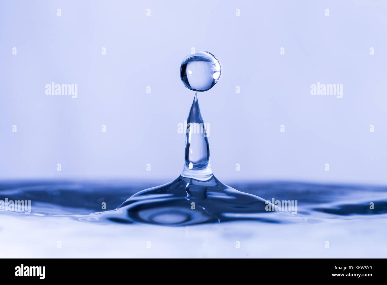 Close up of water drop dropping into water Stock Photo - Alamy