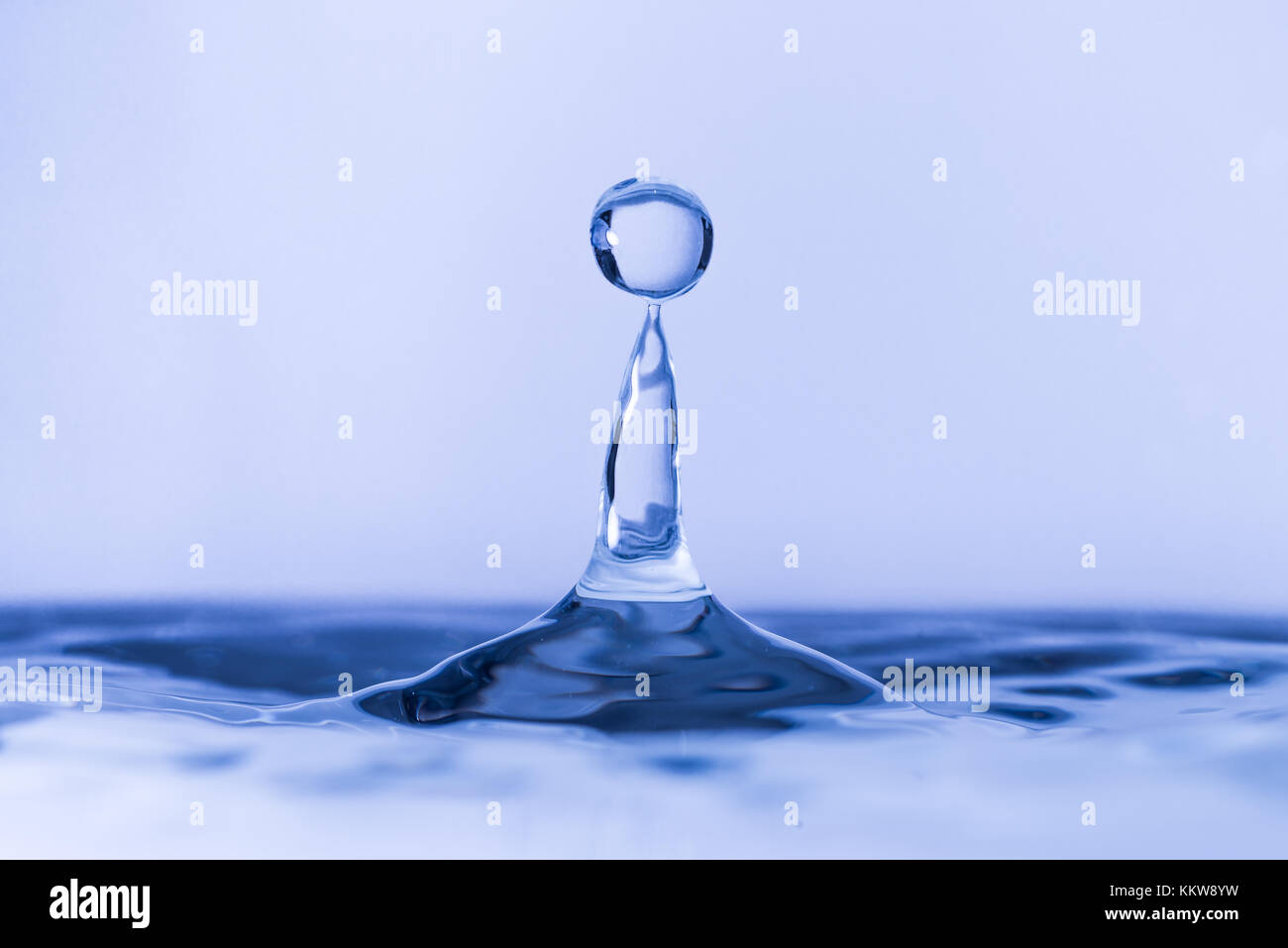 Close up of water drop dropping into water Stock Photo - Alamy