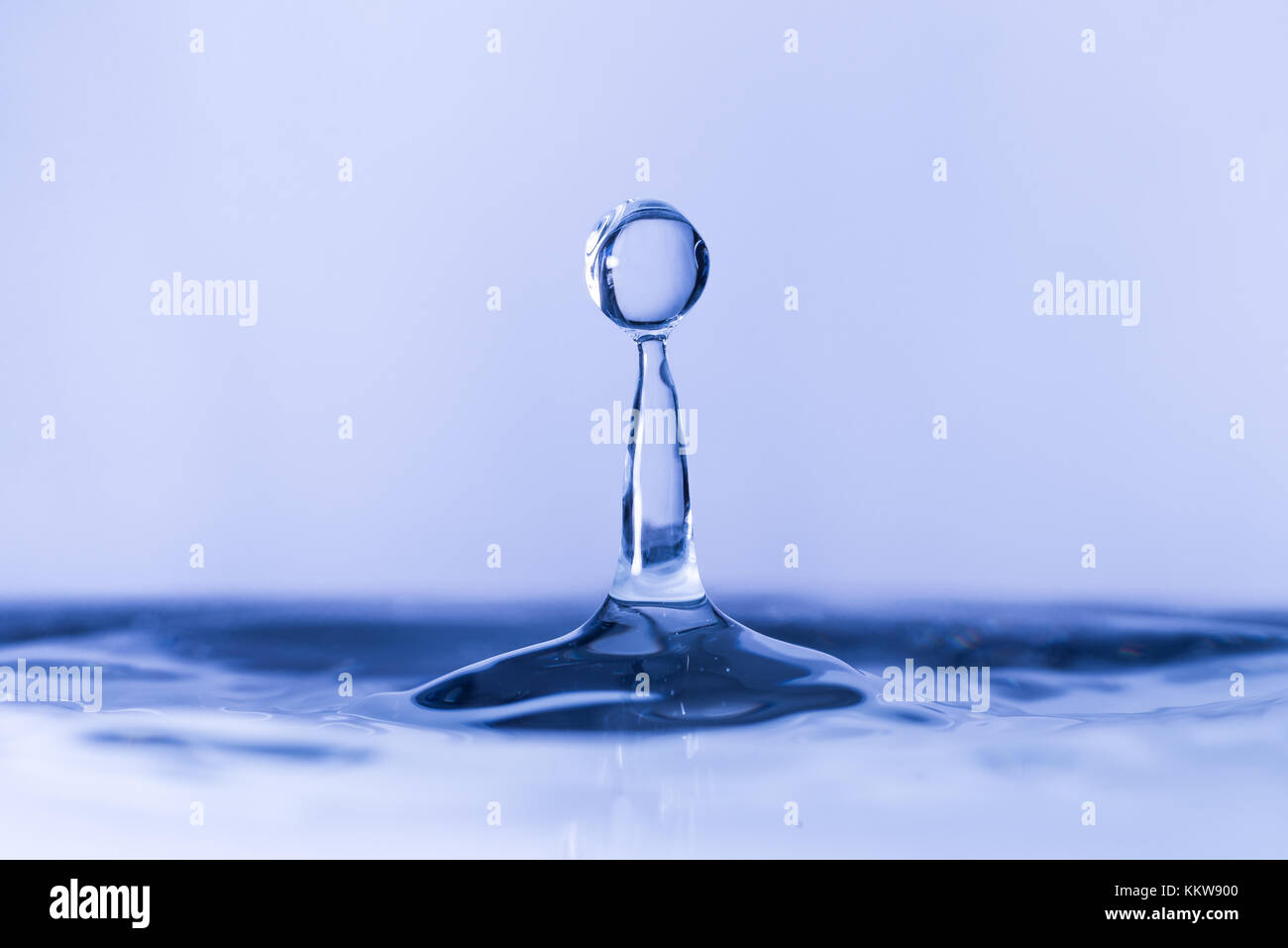 Close up of water drop dropping into water Stock Photo - Alamy